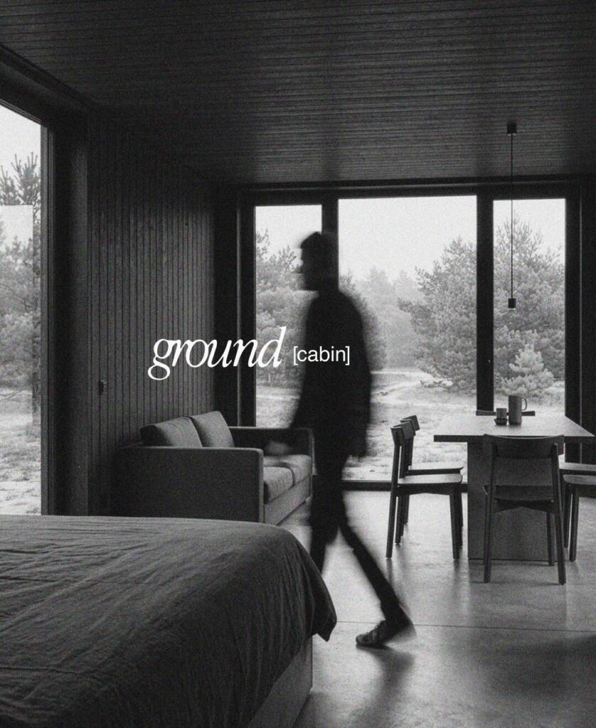 Schwarzweißes Interieur der Ground Cabin mit Person und Blick in den Wald