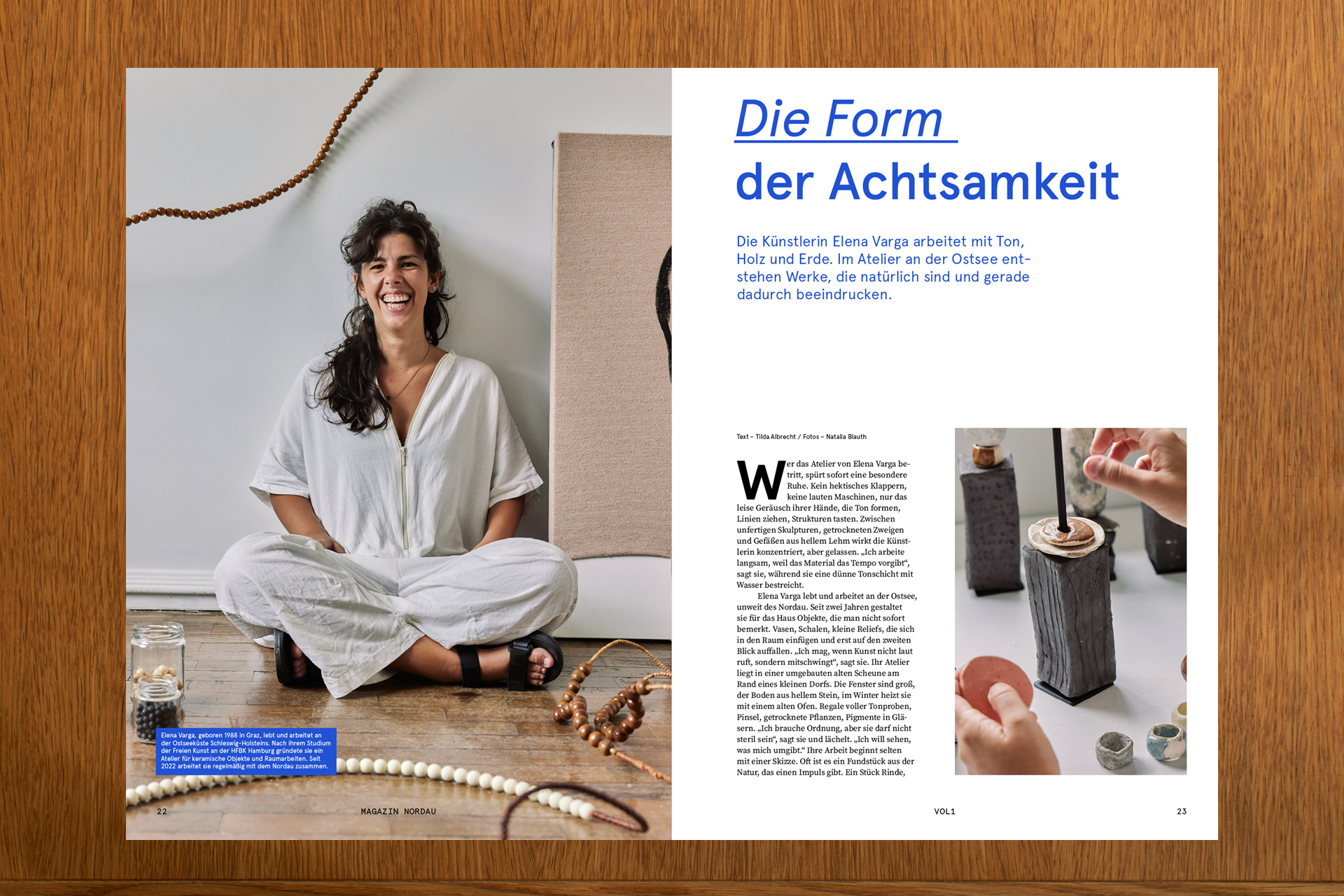Frau sitzt in hellem Atelier auf dem Boden, daneben Magazinseite über Keramikkunst